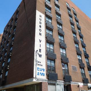 A view of the Hudson View apartment building, showcasing its brick facade and sign.