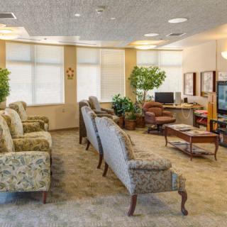 A cozy waiting room with comfortable seating, a television, and natural lighting.