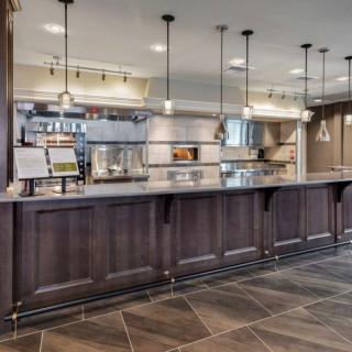 A modern restaurant counter and kitchen with stylish lighting.