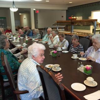 A group of seniors enjoying a meal together in a dining room.
