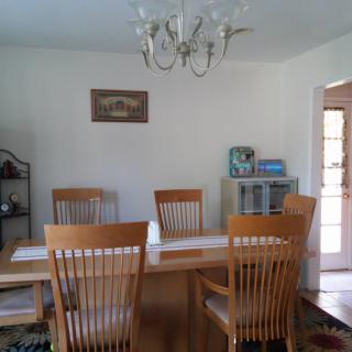 A cozy dining room with wooden furniture and a chandelier.