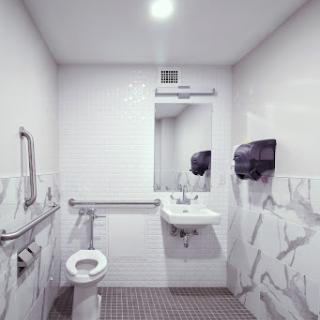 A modern and clean bathroom featuring a toilet, sink, and mirror.