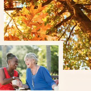 Two women enjoying a conversation outdoors in the autumn surroundings.