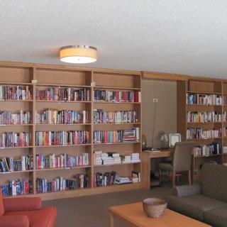 A cozy library interior with wooden bookshelves filled with books and comfortable seating.