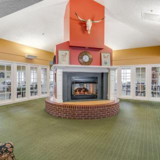 A spacious living room with a central fireplace and skull decoration above the mantel.