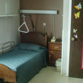 A hospital room with a single bed and medical equipment.