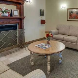 A cozy living room featuring a sofa, a wooden coffee table, and a fireplace adorned with decorative items.