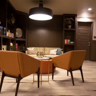 A cozy modern living room setup featuring stylish chairs, a coffee table, and warm lighting.