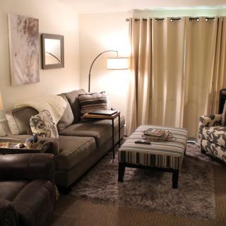A cozy living room with a sofa, armchair, and coffee table.