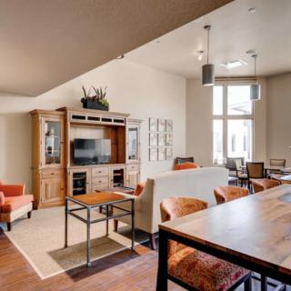 A modern living room with an open layout, featuring wooden furniture and a cozy seating area.