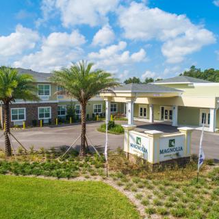 A modern building with palm trees and clear skies.