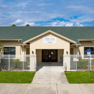 The entrance to a daycare center with a green roof and fenced walkway.