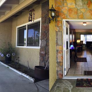 An inviting house entrance with an open front door and stone accents.