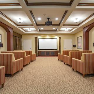 A spacious meeting room featuring comfortable seating and a projection screen.
