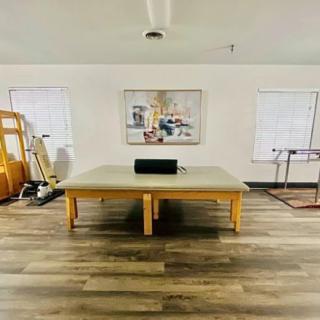 A modern fitness room featuring a Pilates reformer and other exercise equipment.