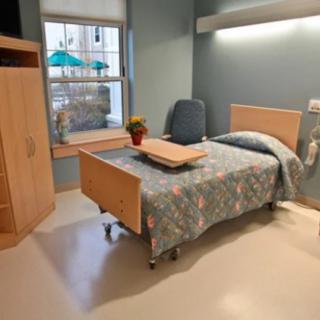 A clean and well-organized hospital room with a single bed.