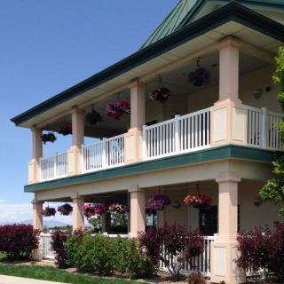 A two-story building with balconies adorned with hanging flowers.