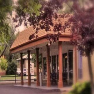 A quaint, columned building surrounded by trees.