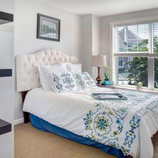 A cozy bedroom with elegant bedding and a large window letting in natural light.