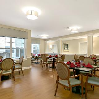 A well-lit dining area with elegantly arranged tables and chairs.