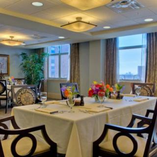 An elegant dining room with neatly arranged tables and colorful floral centerpieces.