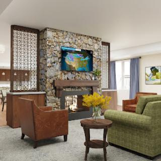 A cozy and modern living room featuring a stone fireplace, comfortable seating, and artistic decorations.