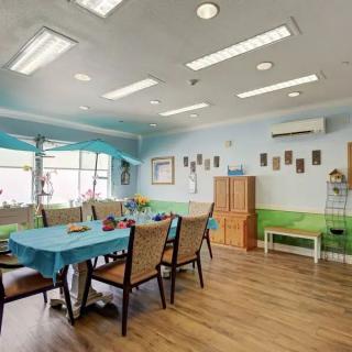 A cozy and well-lit dining area with tables and chairs, decorated with a homey touch.