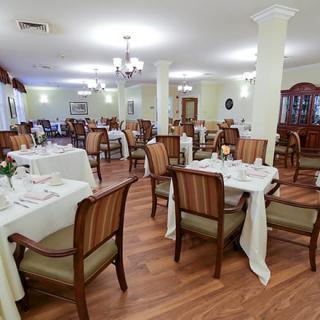 A spacious dining area with elegantly set tables and comfortable chairs.
