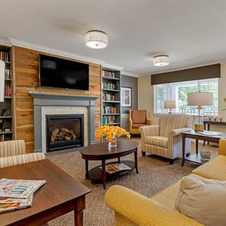 A cozy living room with comfortable seating, a fireplace, and bookshelves.
