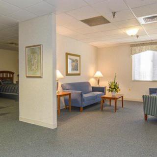 A cozy living room or waiting area with comfortable seating and soft lighting.