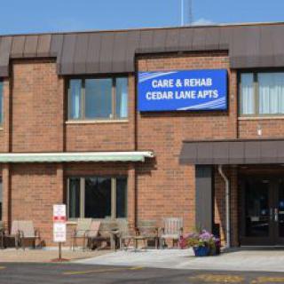 Exterior view of a care and rehab center with Cedar Lane Apartments sign.