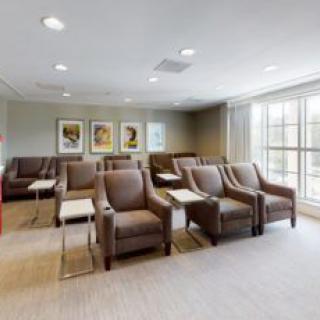A modern waiting room with comfortable seating arrangements and bright natural lighting.
