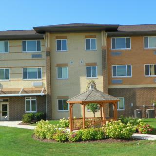 A residential apartment building with a landscaped garden and gazebo.