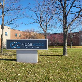 Signage for Ridgewood Home Company against a clear blue sky.