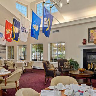 A dining area decorated with military flags and elegant furnishings, featuring a cozy fireplace.
