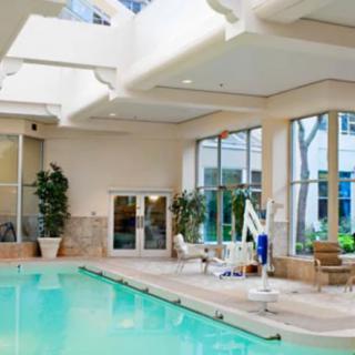 A serene indoor swimming pool area with natural lighting and comfortable lounge chairs.