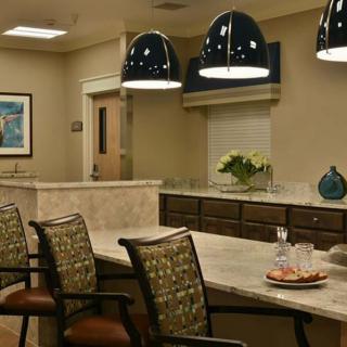 A modern office conference room with a central table, stylish chairs, and overhead lighting.