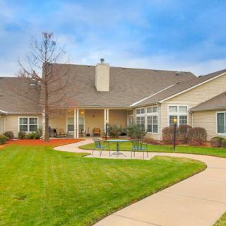 A well-maintained residential building with a green lawn and curved pathway.