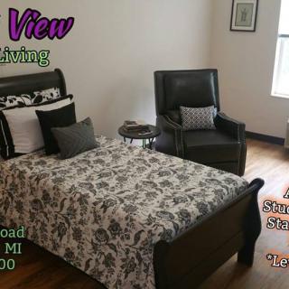 Cozy bedroom interior with a bed and armchair, featured in a living space advertisement.