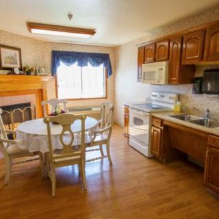 A cozy kitchen and dining area with wooden cabinets and a fireplace.