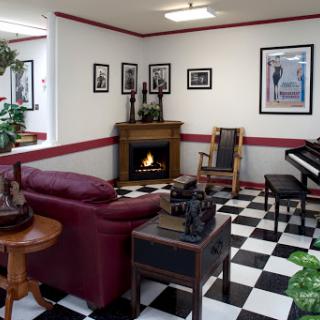 A cozy living room featuring a fireplace, piano, and stylish dcor.