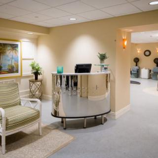 A modern reception area with a curved desk and comfortable seating.