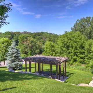 A serene view of a garden pavilion surrounded by lush greenery.