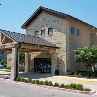 A modern commercial building featuring a stone facade and wooden accents.