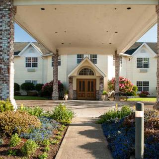 A welcoming entrance of a residential or commercial building with landscaped gardens.