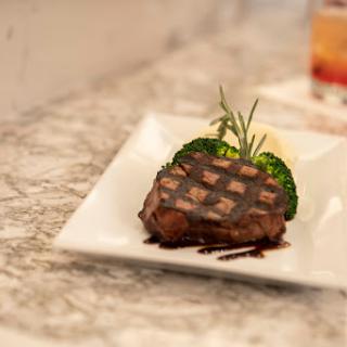 A beautifully grilled steak served with fresh herbs on a stylish plate.