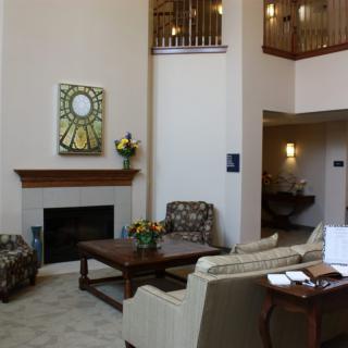 A modern living room with a fireplace, artwork on the wall, and stylish furniture.