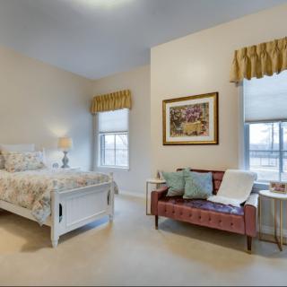 A cozy bedroom with a bed, sofa, and elegant decor.