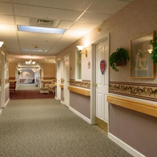 A warmly lit hallway with decorated walls and multiple doors.