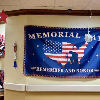 A decorative banner commemorating Memorial Day, featuring the American flag and a call to remember and honor those who served.